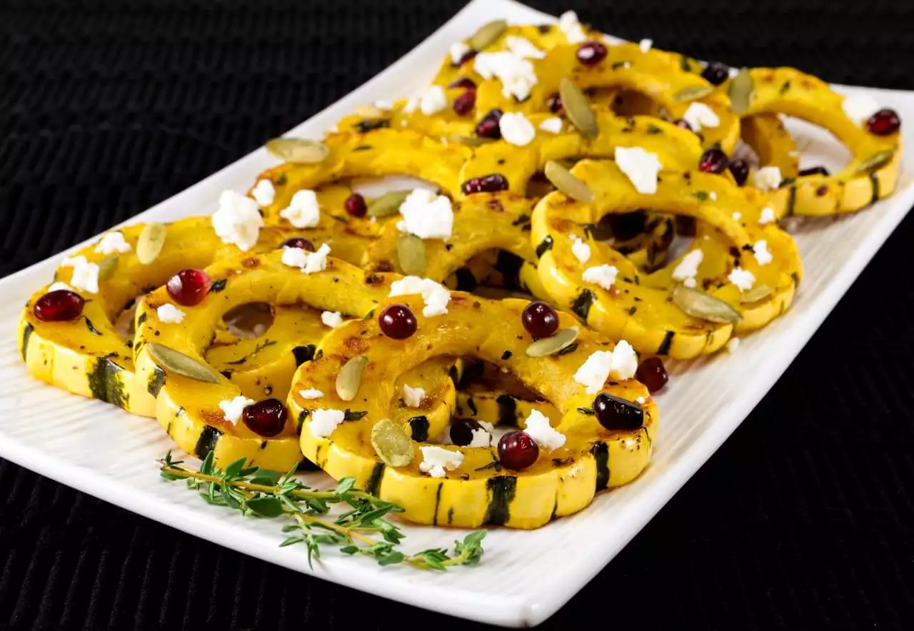 Herb Roasted Delicata Squash Topped with Pomegranate Seeds, Pepitas, and Feta